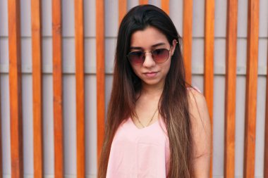 Açık havada güneş gözlüğü takan genç bir kadının portresi.