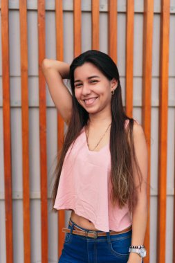 Güzel, güler yüzlü, kaygısız kadın açık havada kameraya bakıyor.