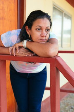 Evinin önünde düşüncelere dalmış kadın