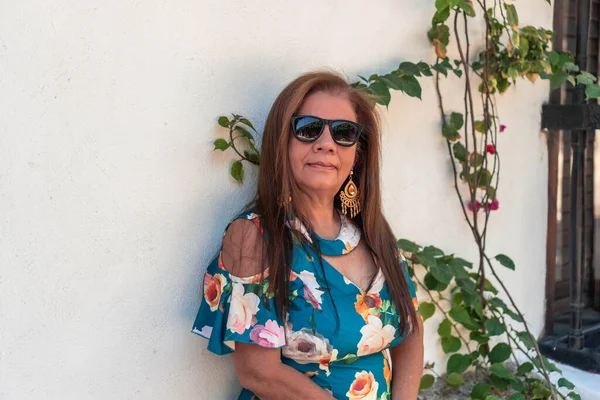 Uzun saçlı, elbise giyen son sınıf Latin bir kadın.