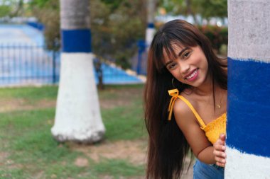 Genç İspanyol kız parkta mutlu bir şekilde yürüyor..