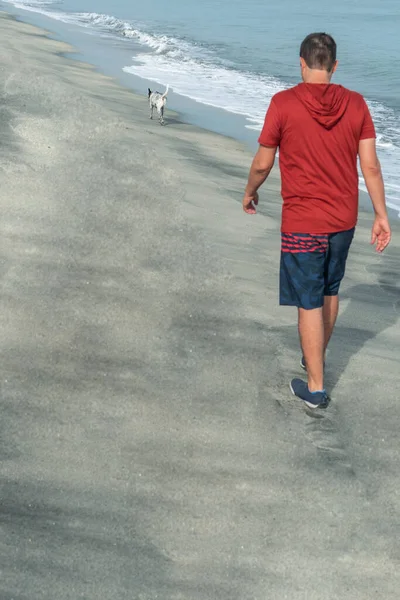 Man on his back walking on the beach on a summer's day