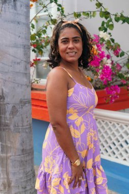 Çiçeklerle dolu bir evin önünde 40 yaşında güzel bir kadın.