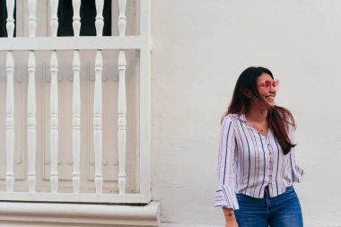 Gülümseyen kadın şehirde yaya yolunda dikilirken dönüyor.