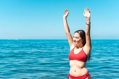 Genç kız denizde banyo yaparken eğleniyor.