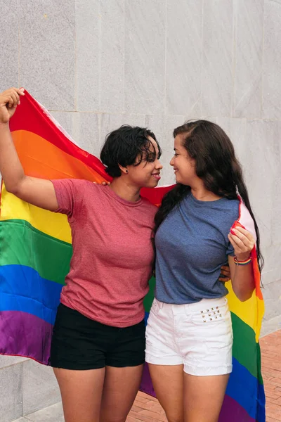 拉丁女同性恋夫妇与Lgtb的旗帜在城里 Lgbt概念 — 图库照片