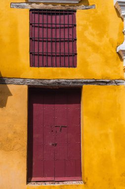 Bir evin pencere ve kapısı, sarı bir duvar.