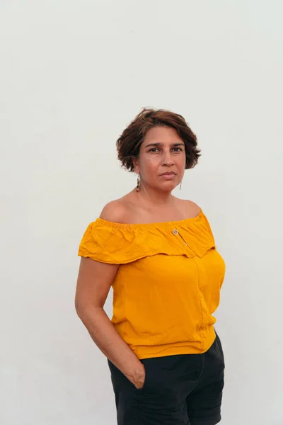 Kendine güvenen, kısa saçlı, olgun bir kadın.