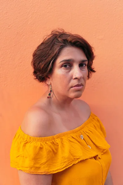 Renkli turuncu geçmişi olan olgun Latin bir kadın..