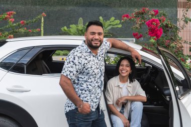 Gülümseyen çift beyaz arabalarıyla dışarıda gezmekten zevk alıyorlar.