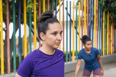 Atletik kadın arka planda başka bir kadınla çalışmaya odaklanmış ve hazır.