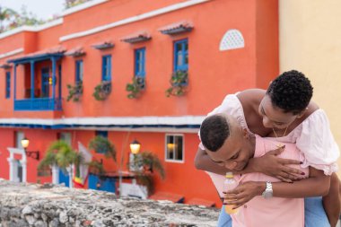 Genç çift Cartagena 'da renkli bir sokakta gülüyor ve eğleniyor.