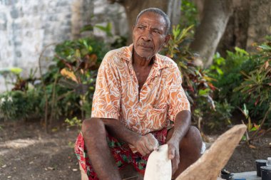 Yaşlı esnaf odun yontuyor, geleneksel zanaat ve kültür mirasını koruyor.
