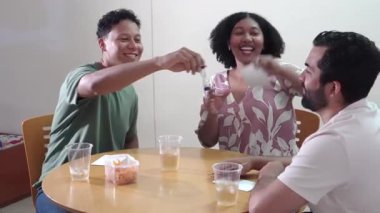 Üç mutlu çok kültürlü arkadaş evde masa üstü oyunu oynarken eğleniyorlar.