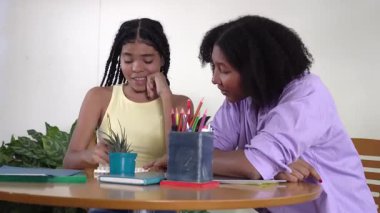 Hasta Afro-Amerikan annesi, hayal kırıklığına uğramış kızına okul ödevlerini öğretiyor.