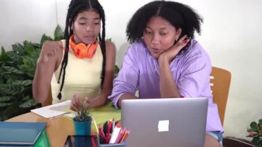 Afrikalı Amerikalı anne, genç kızına online eğitim için dizüstü bilgisayar kullanıyor.