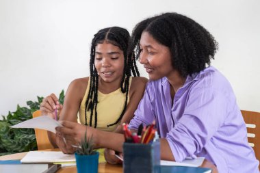 Siyahi kadın eğitimci ve öğrenci özel ders sırasında belge okuyorlar