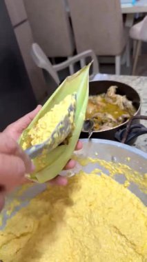 Kişinin elleri geleneksel bir Brezilya yemeği hazırlıyor mısır kabuğunu mısır unu mısır unu ve tavukla dolduruyor.