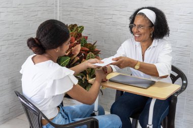 Bir zarf alan genç kadın, akademik başarıyı ve gelecekteki eğitim fırsatlarını kutluyor