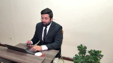 Takım elbiseli komik bir işadamı bilgisayarında çalışırken gerçeküstü bir yüze sahip.