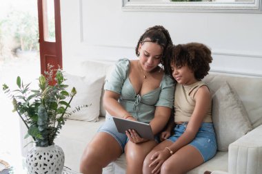 İki kız kardeş evdeki dijital tablette bilgiyi ve öğrenimi paylaşıyor.