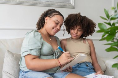 Ablam küçük kız kardeşime nasıl yazılacağını öğretiyor, bilgiyi aktarıyor.