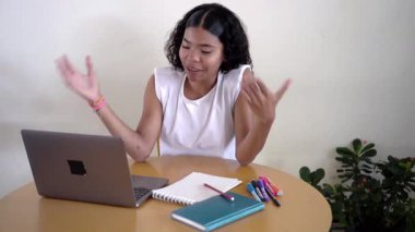 Genç kız çevrimiçi bir video görüşmesi sırasında bitirdiği ödevini hevesle paylaşıyor.