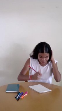 Mutlu genç kız masasında oturuyor, yaratıcı işini başarıyla tamamlıyor ve ilham alıyor.