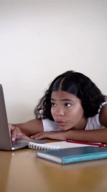 Dizüstü bilgisayarında ödevleriyle boğuşan genç bir kız yorgunluk belirtileri gösteriyor ve aniden odaklanıyor.