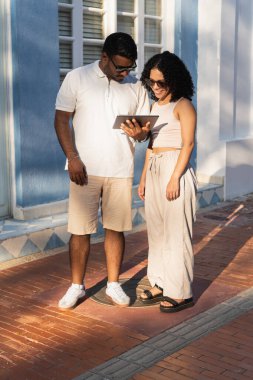 Çift tableti paylaşarak teknolojinin ve birlikteliğin tadını çıkarıyor.