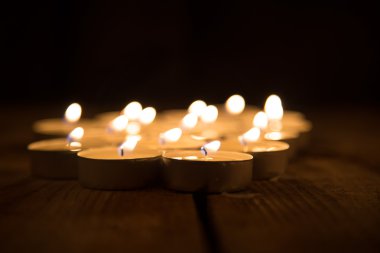 ahşap yüzeye karanlıkta yanan birkaç mum