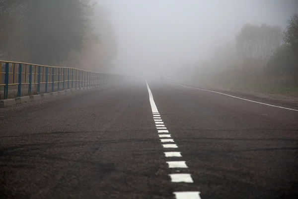 秋の霧の中のアスファルト道路 ストック画像