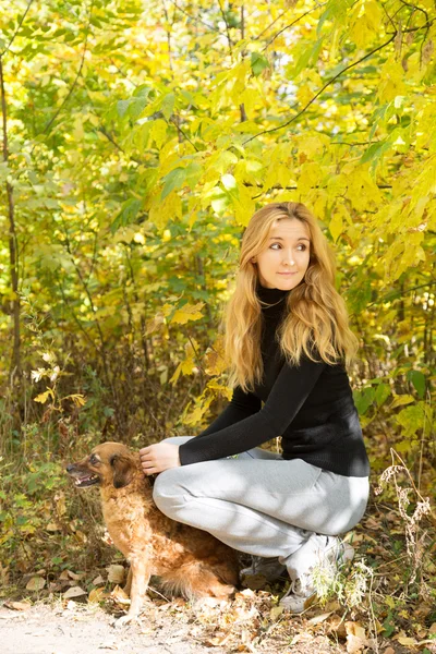 秋公園で赤犬を持って笑顔の女の子 — ストック写真