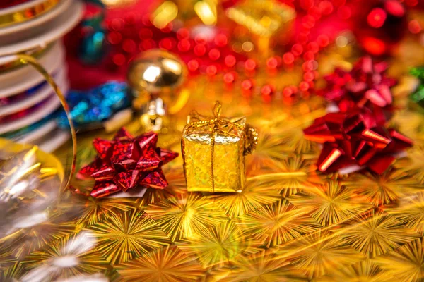 Small golden gift-box near red bead and bow close-up — Stock Photo, Image