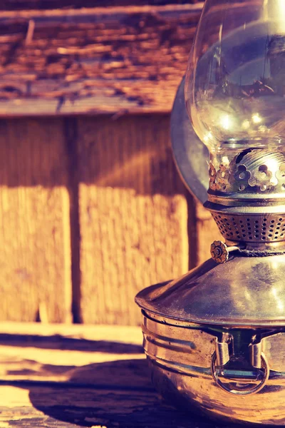 Старая керосиновая лампа на фоне старой деревянной желтой стены — стоковое фото