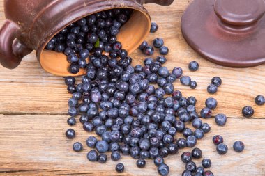 yaban mersini ya da pot ahşap arka plan üzerinde dağınık ahududu