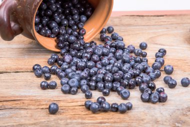 yaban mersini ya da pot ahşap arka plan üzerinde dağınık ahududu