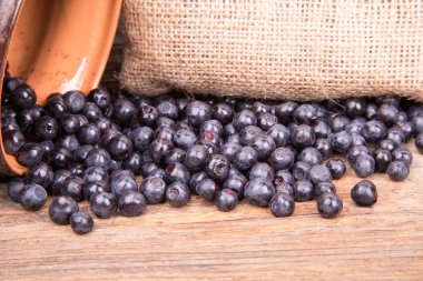 yaban mersini ya da pot ahşap arka plan üzerinde dağınık ahududu