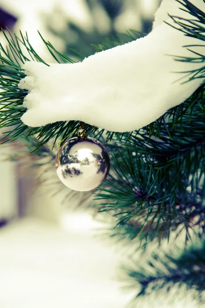 Baubles hanging on a christmas tree covered  snow.retro toning — Stock Photo, Image