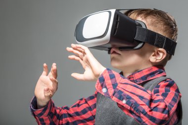 Boy in virtual reality glasses playing the game clipart