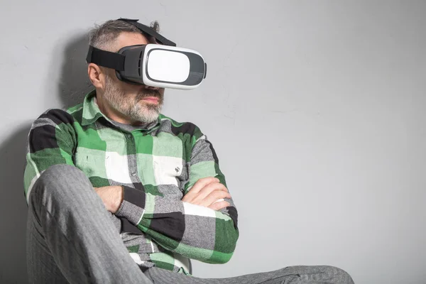 Людина у окулярах віртуальної реальності на сірому фоні — стокове фото