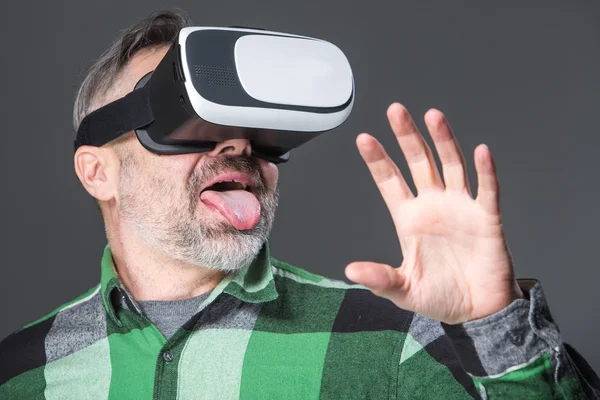 Человек в очках виртуальной реальности над серым — стоковое фото
