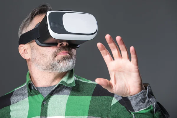 Mann mit Virtual-Reality-Brille vor grauem Hintergrund — Stockfoto