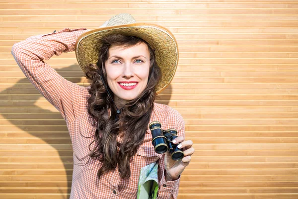 Beautiful woman traveler holding binoculars — Stock Photo, Image