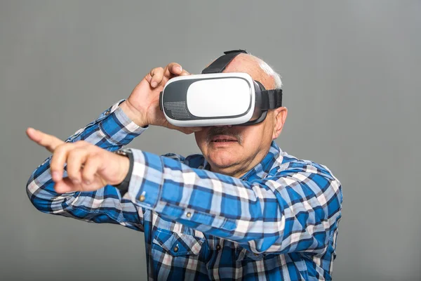 Старик в очках виртуальной реальности веселится — стоковое фото