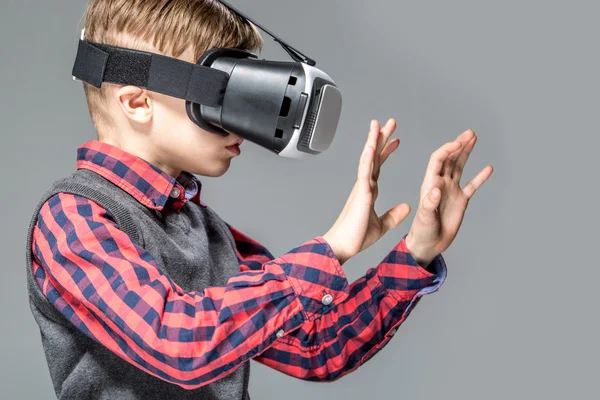 Мальчик в очках виртуальной реальности играет в игру — стоковое фото