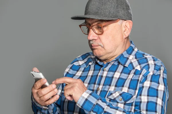 Velho homem ativo usando telefone celular — Fotografia de Stock