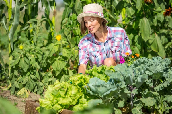 Glücklich lächelnde kaukasische Bäuerin oder Gärtnerin, die in einem Garten arbeitet — Stockfoto