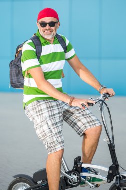 Güneşli bir şehirde bisiklet yakışıklı adam