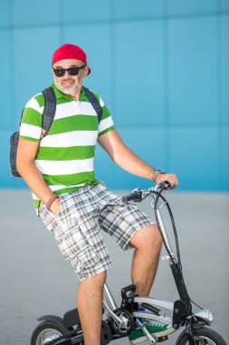 Güneşli bir şehirde bisiklet yakışıklı adam